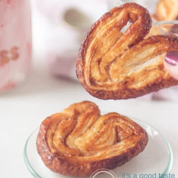 a hand holding an elephant ear cookie and one on a plate