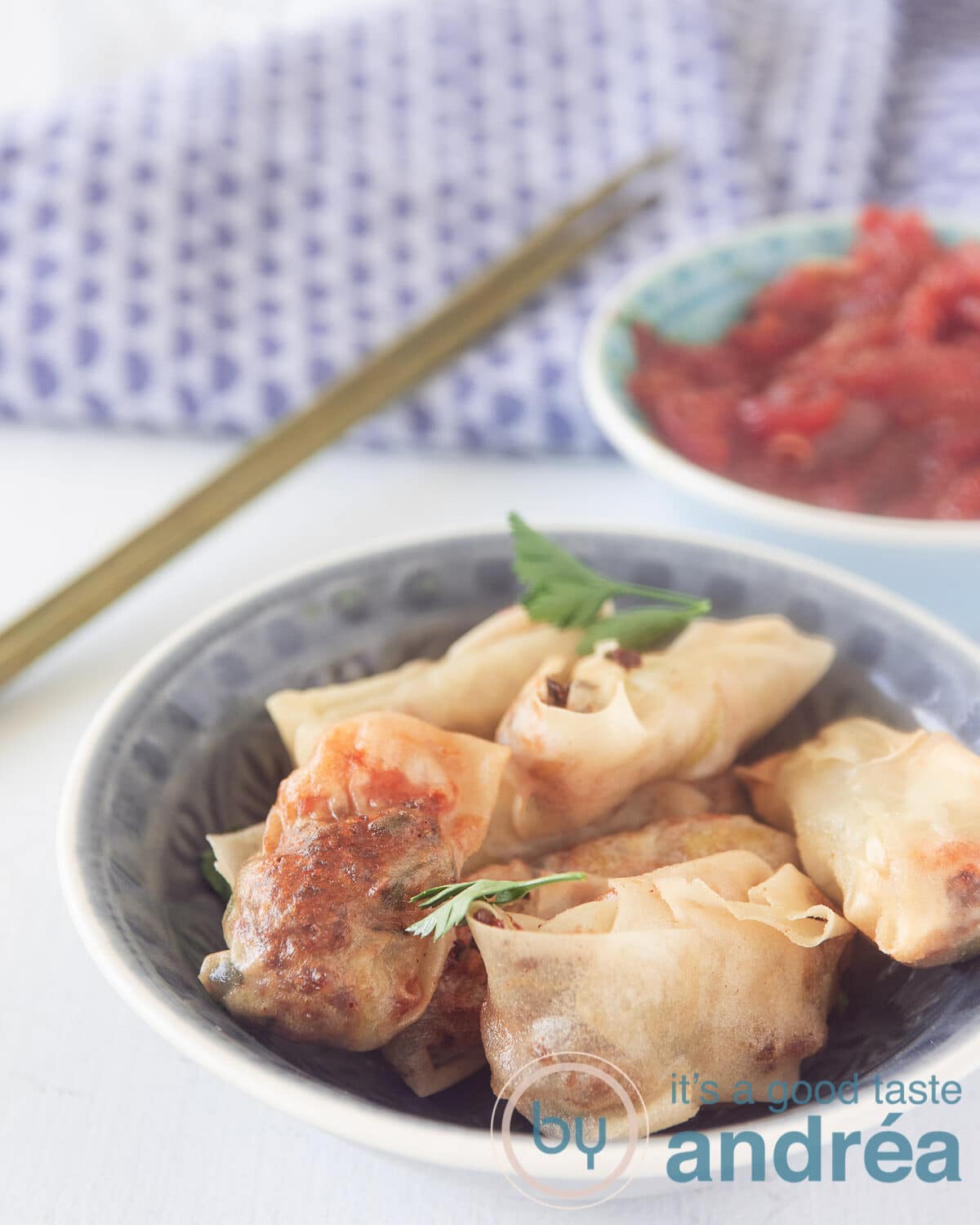 A bowl with Indonesian mini spring rolls and a bowl with a homemade sauce in the back