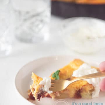 A slice of Spanish tortilla with a dollop of sour cream. A golden fork is taken a bite of it.