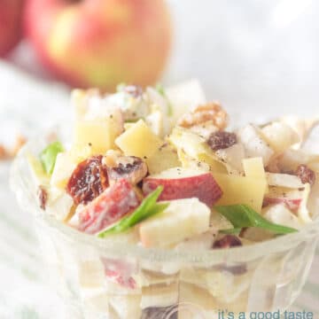 A bowl with brussels endive salad. Two apples in the background