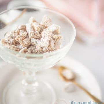 A glass bowl filled with fresh ginger candies. A cup of coffee in the background