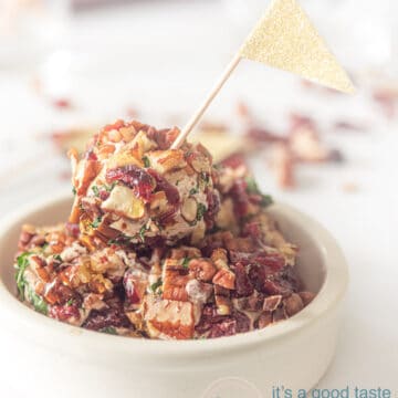 A white dish with goat cheese balls. A golden flag sticks in it