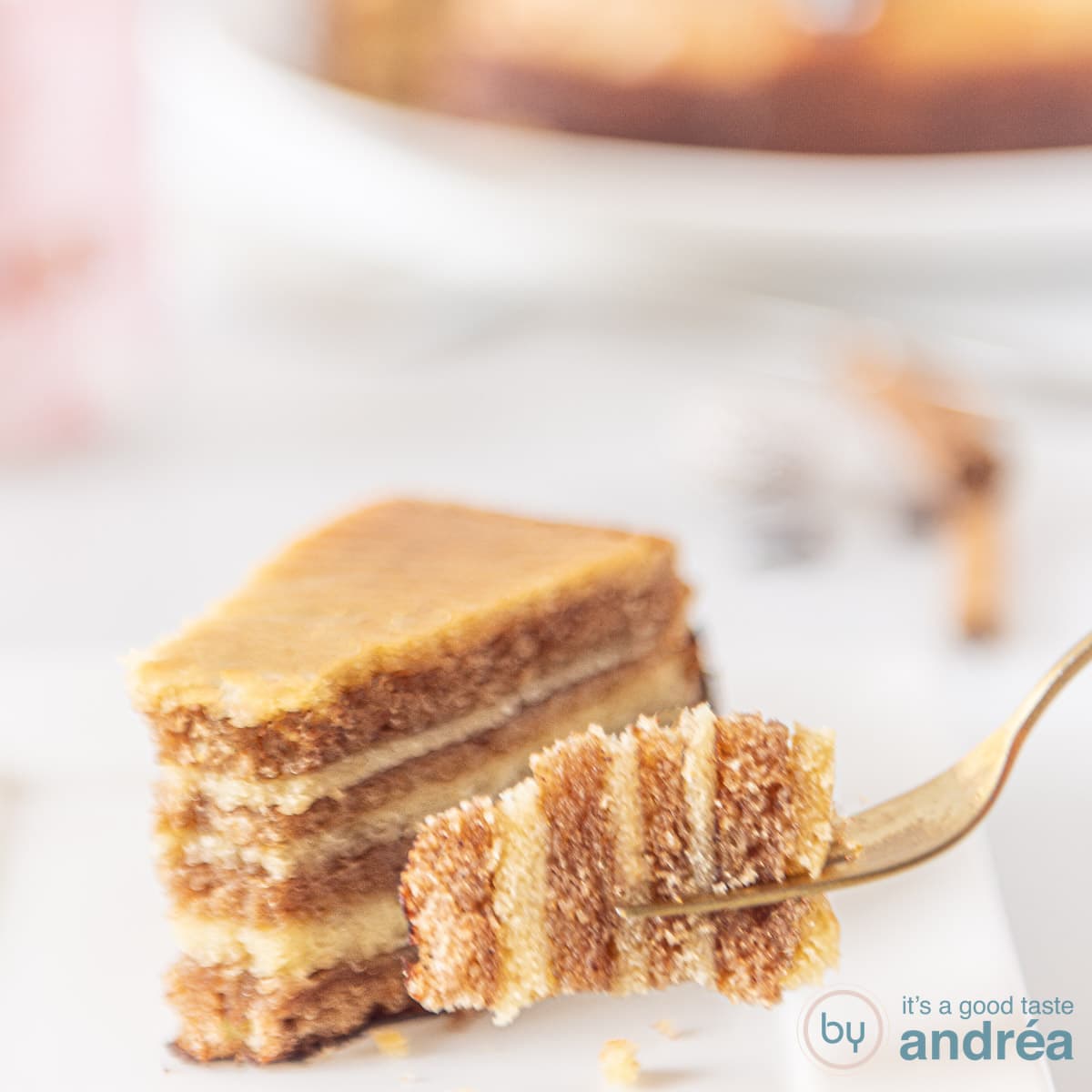 A square picture with a piece of thousand layers cake on a white plate. A fork holding a piece.