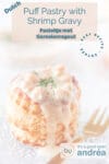 puff pastry basket filled with Dutch shrimp ragout topped with dill and to the right a golden fork