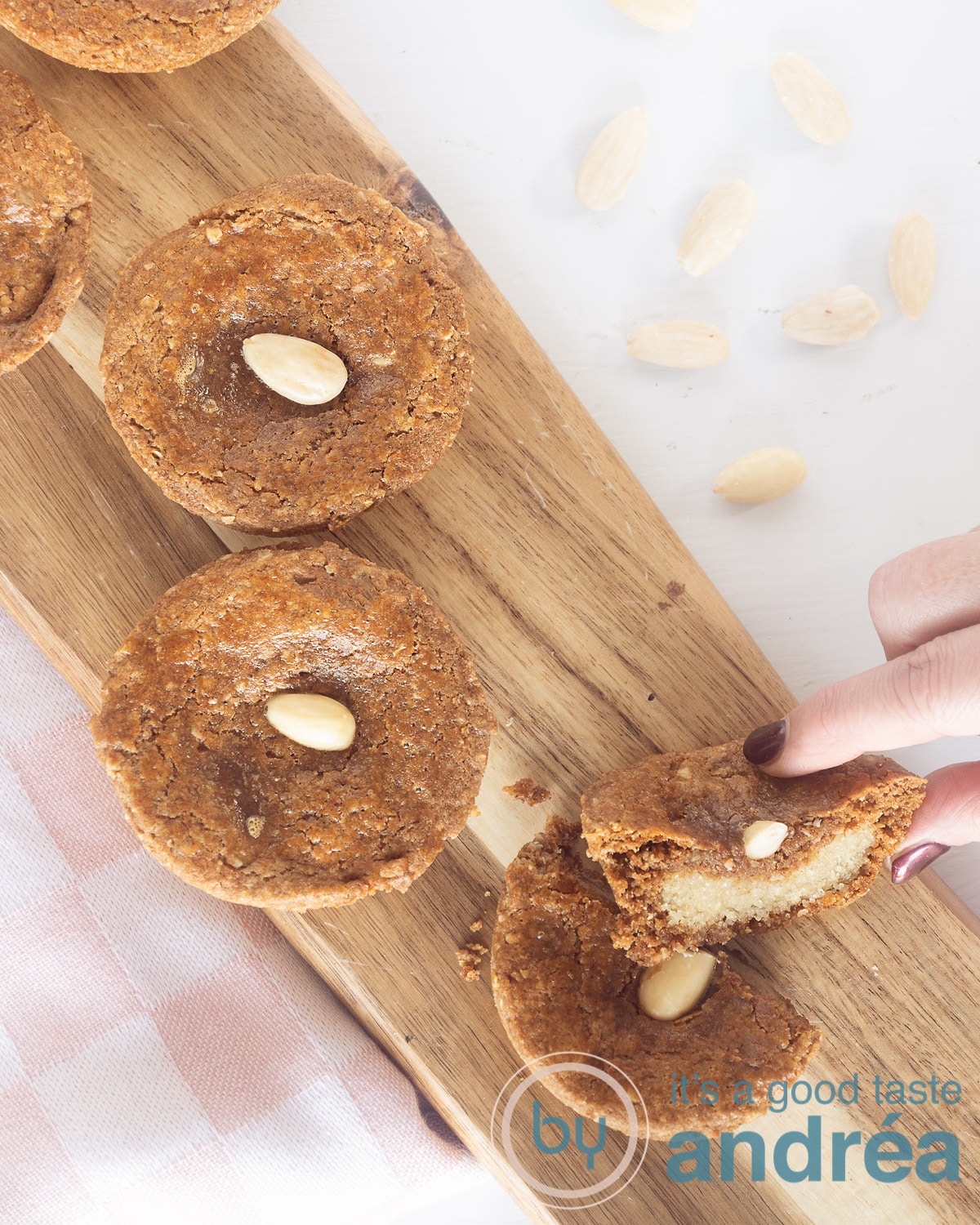 Almond-Filled Dutch Speculaas Cookies 2 Dutch almond-filled spice cookies on a wooden plate. A hand takes a half.