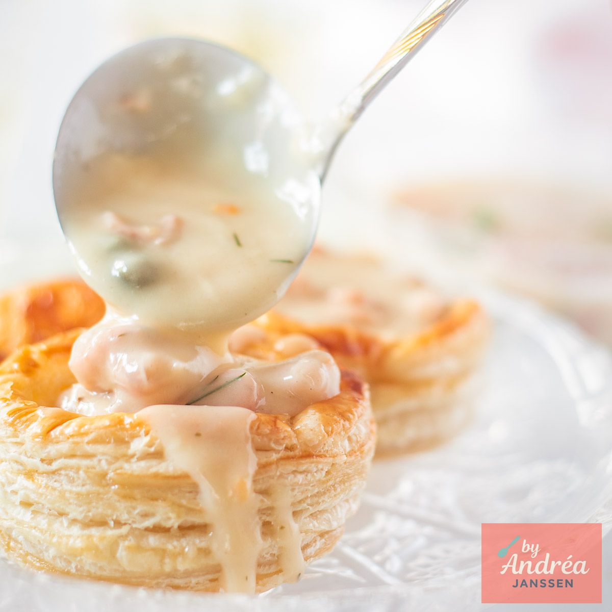 A square photo with a homemade pastry shell (Dutch vol-au-vent) into which ragout is being spooned.