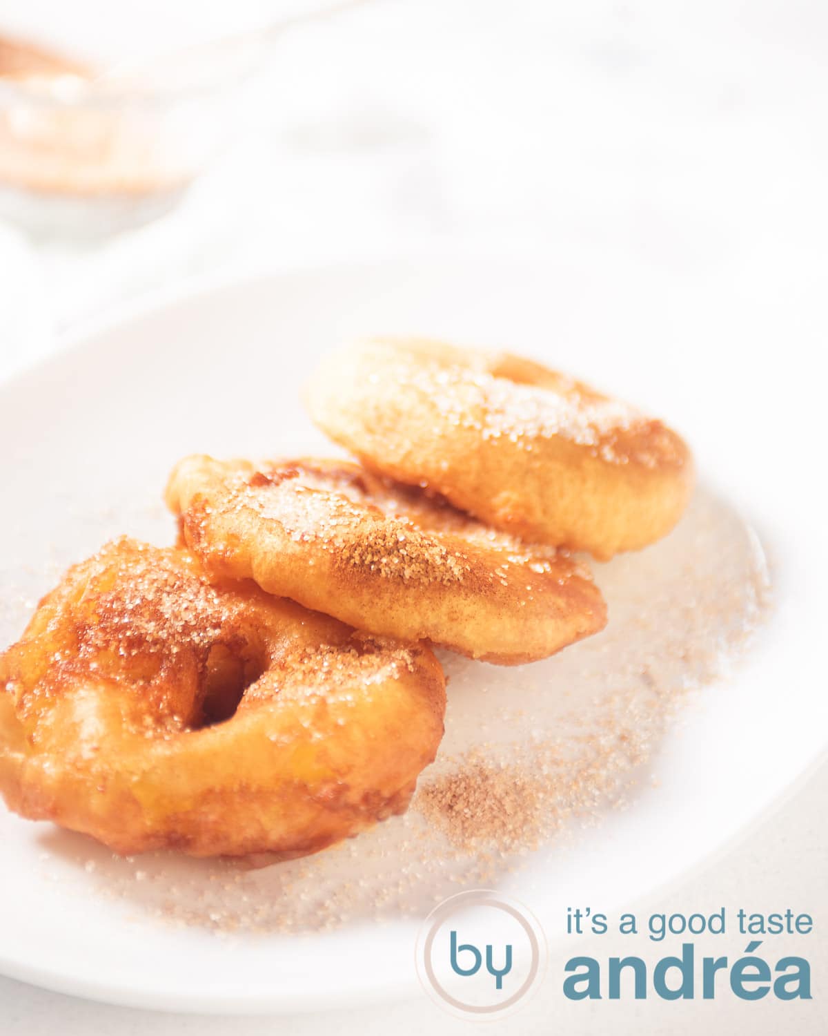 A white bowl with three apple fritters
