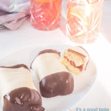 A white bowl with three Dutch Marzipan Pastry (1 cut half open so that you can see the filling). A white background and blood orange iced tea in the background