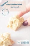 A photo of a hand grabbing a chicken and curry salad toast. A second cracker at the bottom. A text overlay describes the photo.