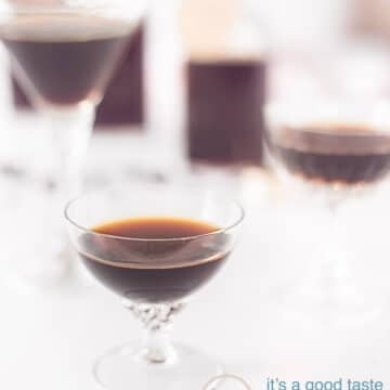 All glasses filled with Tia Maria on a white background. In the background bottles filled with Tia Maria