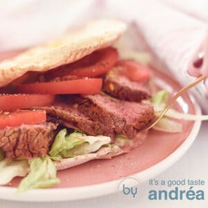 A square photo with roast beef from the BBQ, flatbread, tomato and iceberg lettuce
