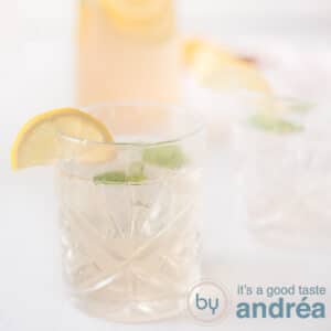 A square photo with two glasses of lemon and ginger lemonade with mint and lemon