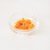 Orange zest in a glass bowl on a white background