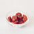Semi-sun-dried tomatoes in a glass dish on a white background
