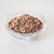 A glass bowl filled with granola on a white background