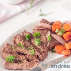 A square photo with strips of sirloin steak garnished with parsley and served with shallot and carrots