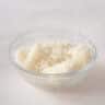 A glass bowl with cauliflower rice on a white background