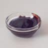 Date syrup in a glass bowl on a white background
