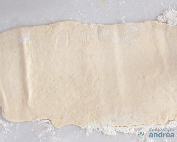 Dough stretched out on a white surface.