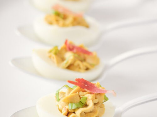 Italian flavored deviled eggs with pancetta and balsamic on 4 white spoons