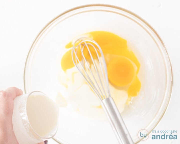 Cream and eggs mixed in a glass bowl