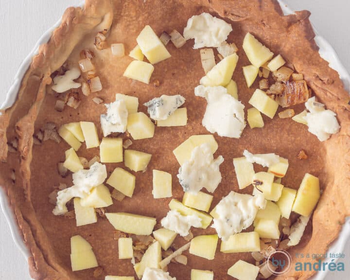 Spread, apple, onion and gorgonzola on the bottom of the quiche form.