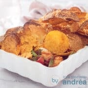 a square photo of a chicken casserole topped with nachos and tortilla's