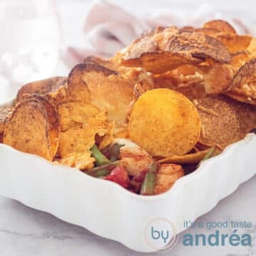 a square photo of a chicken casserole topped with nachos and tortilla's