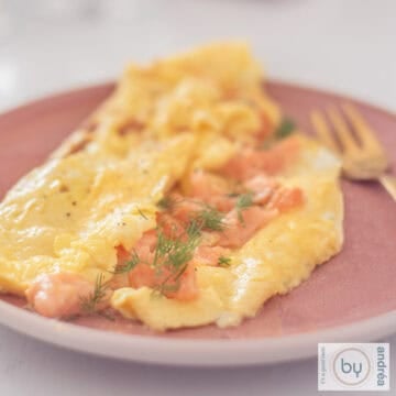 Omelette with smoked salmon and chives on a pink plate, A square picture