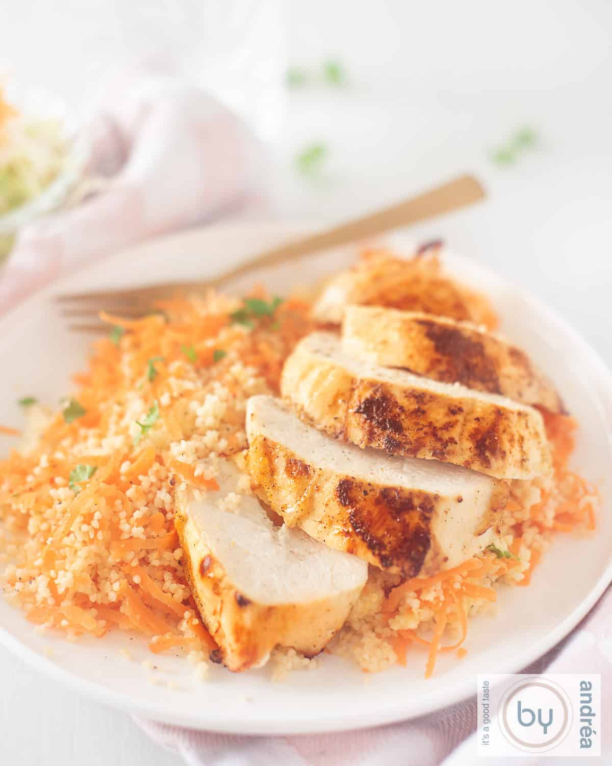 A height photo of Ras el Hanout chicken with spicy carrot couscous on a white plate