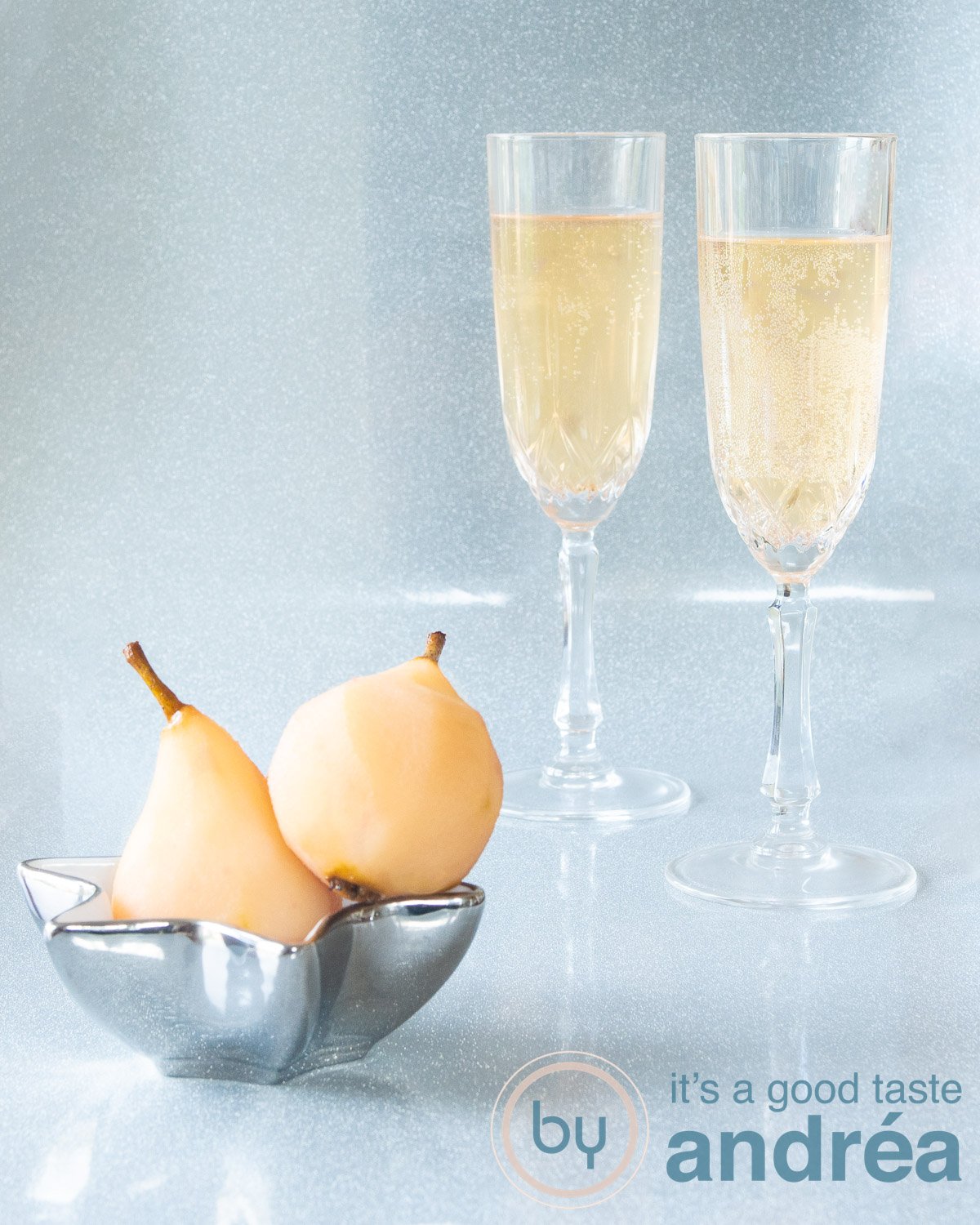 Two delicious stewed pear champagne cocktails in the background. In the foreground a bowl with stewed pears.