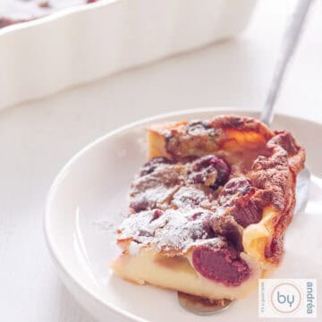 A square picture of a white plate with cherry clafoutis