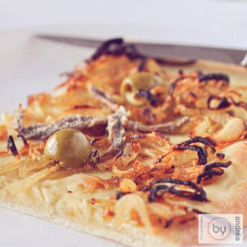 a square photo with a piece of Pissaladière on a plate