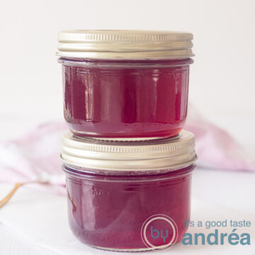 Redcurrant jam with port wine, two jars on top of eachoter on a white background