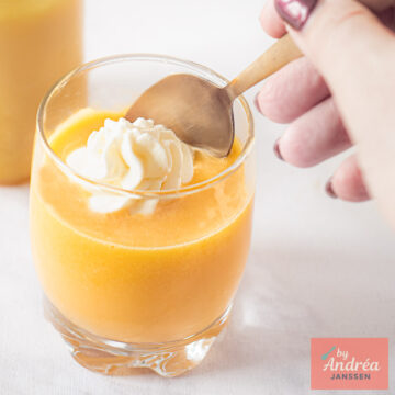 Advocaat with whipped cream seen from above, with a pink tea towel