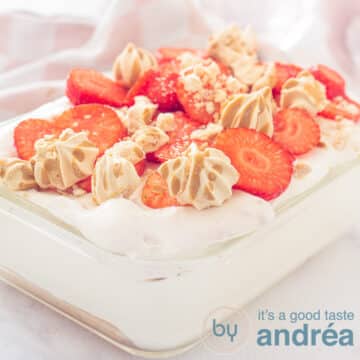 A square photo with a glass bowl filled with strawberry tiramisu on a white background