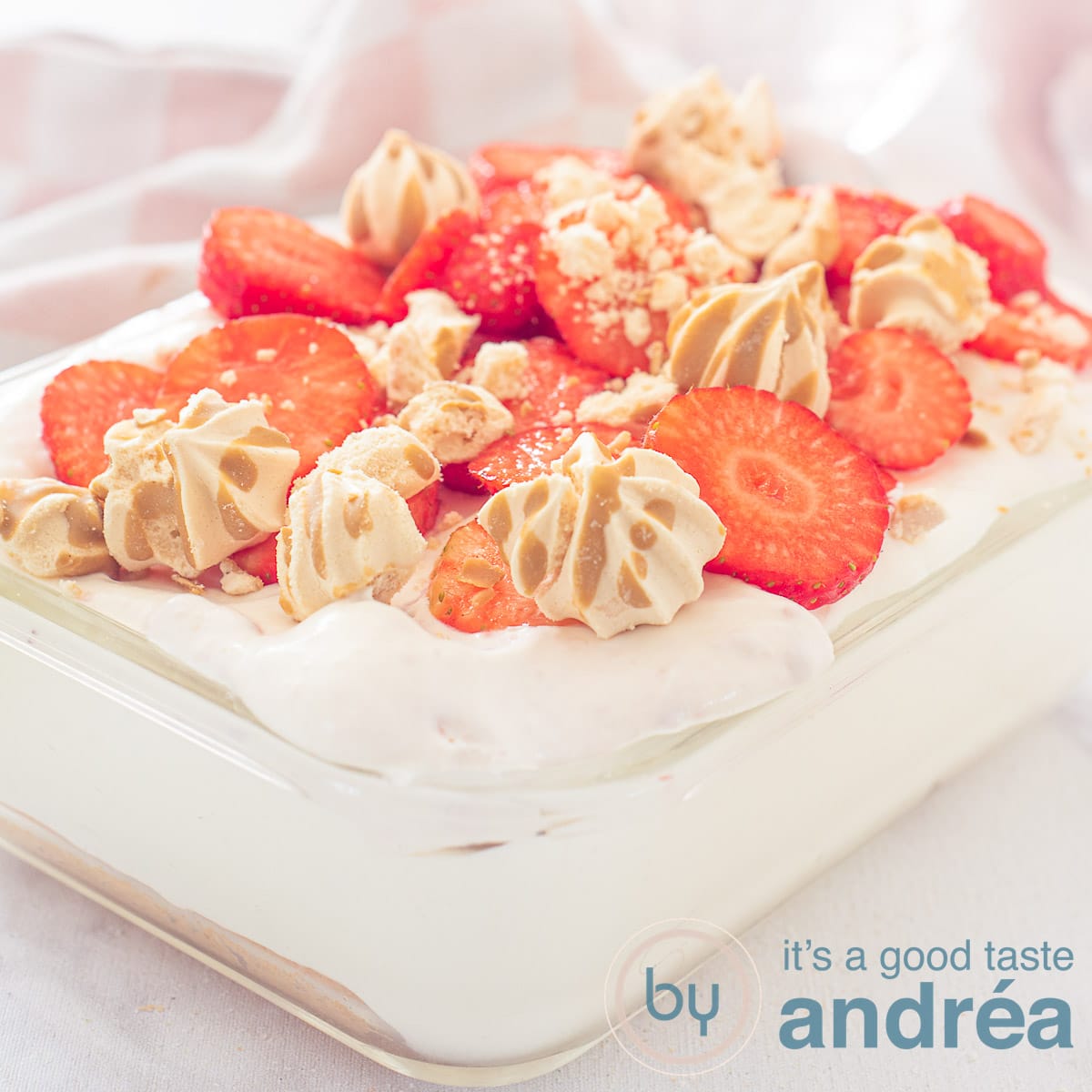 A square photo with a glass bowl filled with strawberry tiramisu on a white background