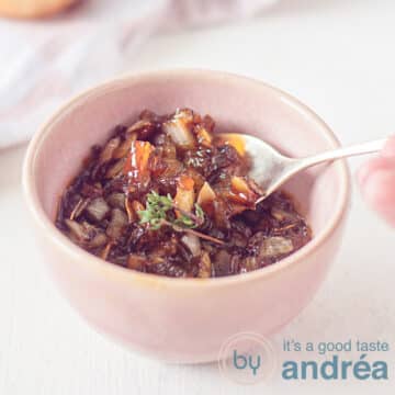 A square photo with a pink bowl filled with caramelized onion sauce. A spoon scoops some out. A white background