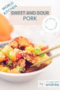 Part of a gray dish filled with Koe lo Yuk. Two chopsticks grab a piece of meat. A text overlay: sweet and sour pork just like Chinese, world cuisine, easy recipe, tasty.