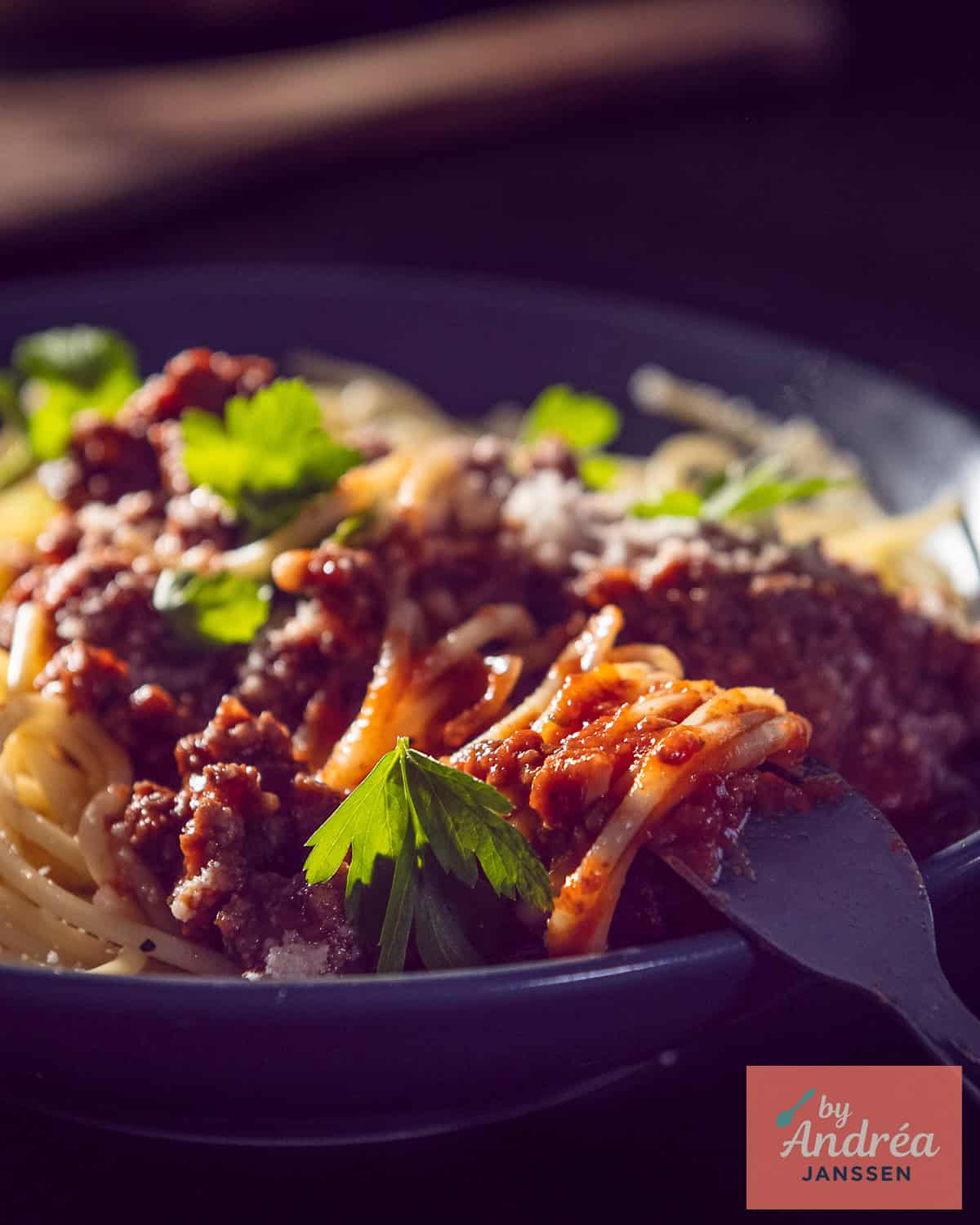 Part of a gray bowl of pasta with bolognese sauce made in 30 minutes.