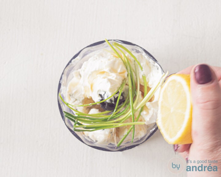 A bowl with gorgonzola, sour cream, chives and lemon is squeezed out above.