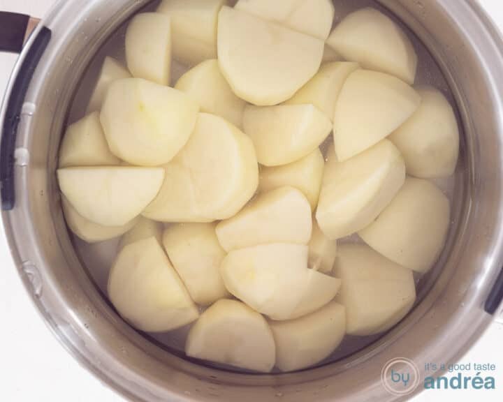 A pan filled with peeled potatoes and water.