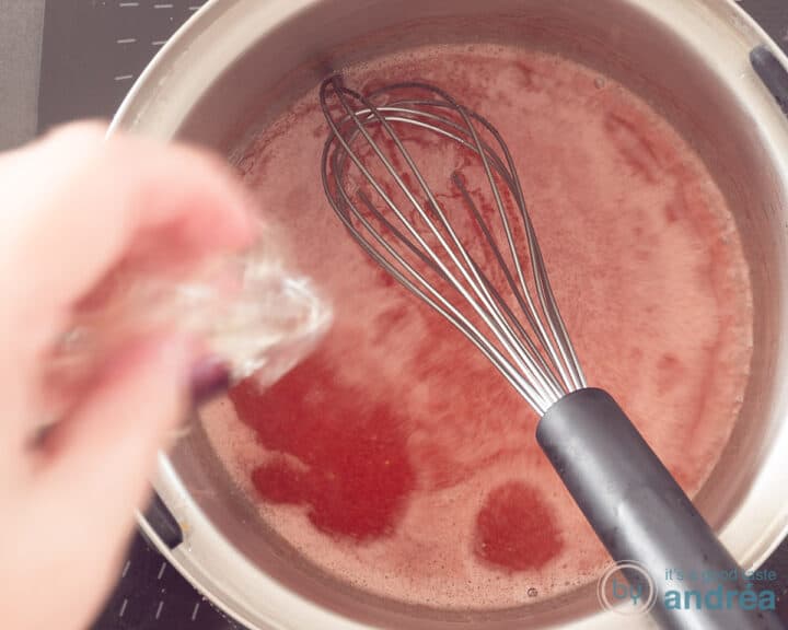A saucepan with strawberry sauce in which gelatin is dissolved.