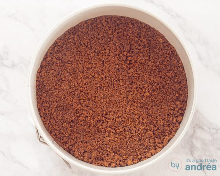 A springform pan filled with a Speculoos butter base.