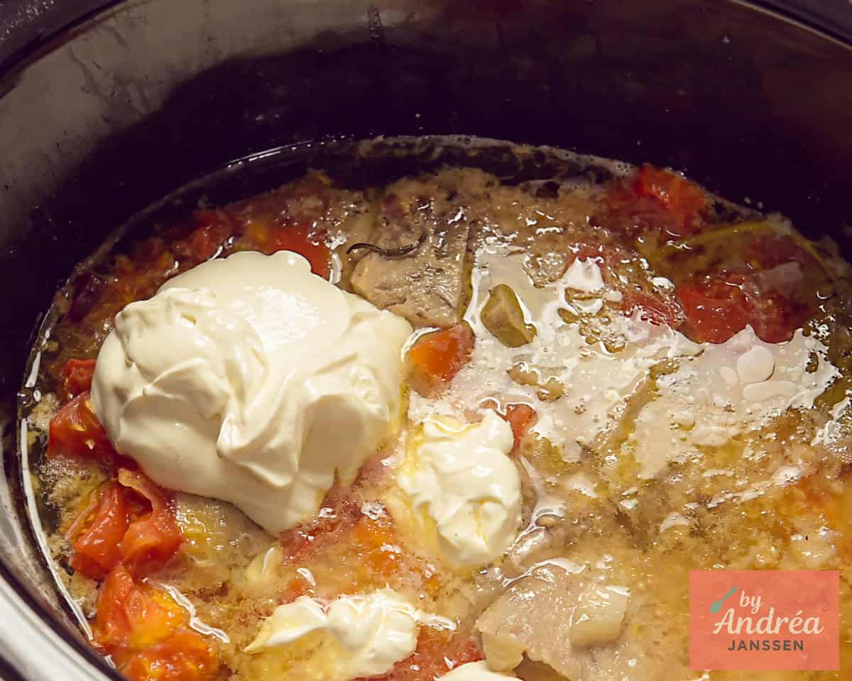 Heavy cream added to the slow cooker with ham and a flavorful sauce.