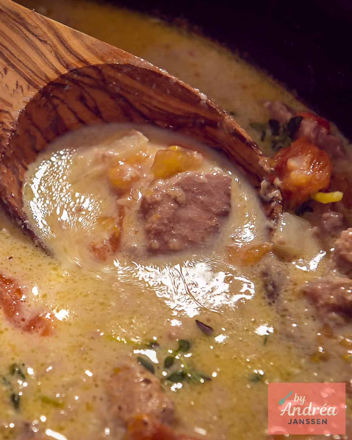 Part of a slow cooker with ham steaks in a creamy sauce