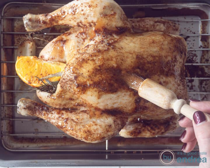 A whole roasted chicken on a grill covered with honey orange sauce.