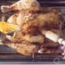 A whole roasted chicken on a grill covered with honey orange sauce.