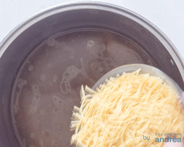 Vermicelli noodles are added to the pot of chicken soup