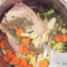 Water is poured into the pan with the chicken, vegetables and herbs